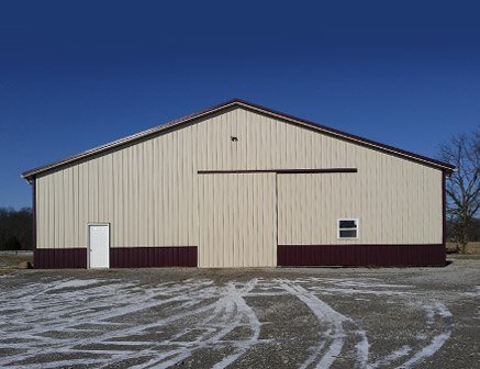 Horse riding arena pole barn in stone color with one main entrance