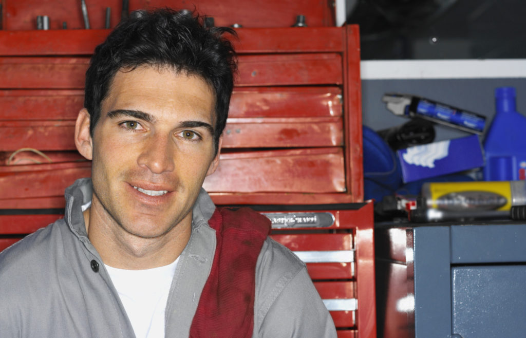 Smiling man in front of toolbox in pole barn garage.