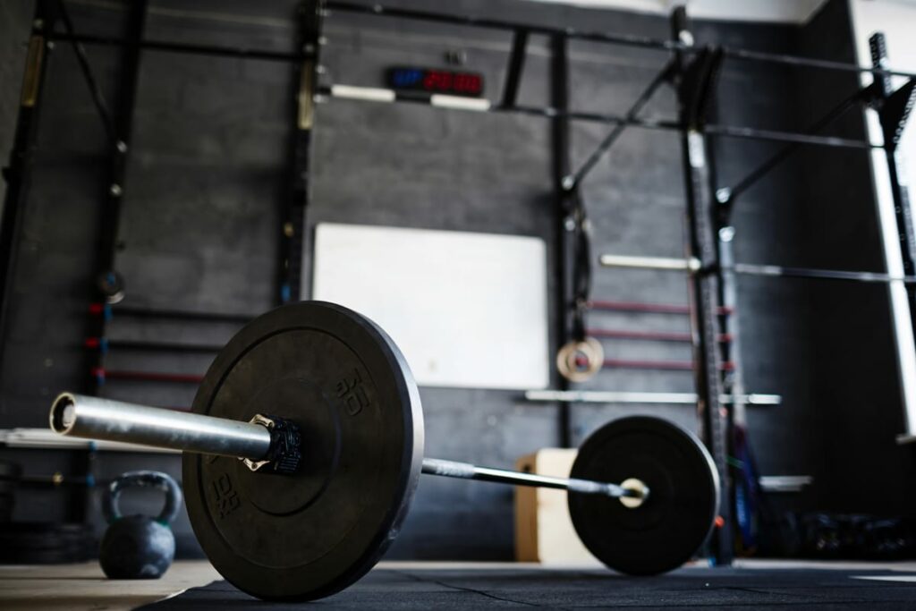 A pole barn gym with barbells and power racks in the back