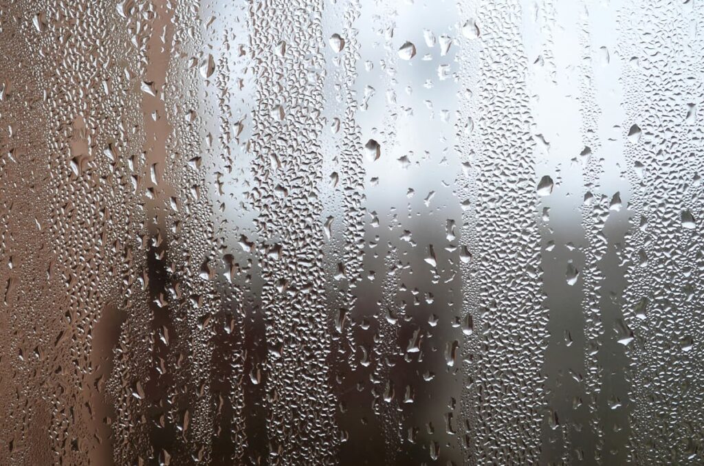 A pole barn window with condensation on it