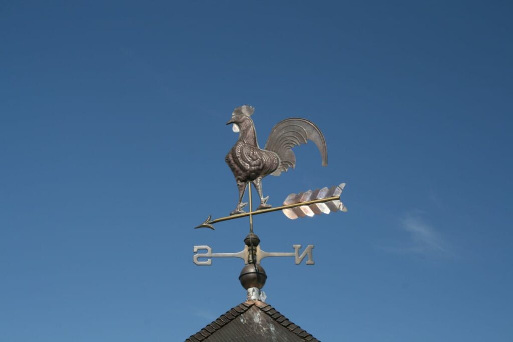 A weathervane on top of a pole barn